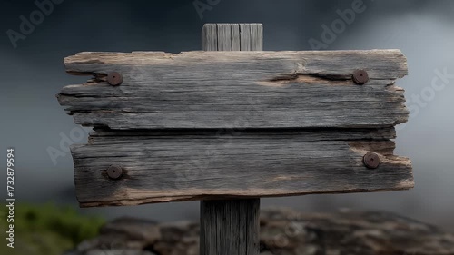 A weathered wooden picket sign with cracked boards and splintered edges stands on a crooked post, surrounded by swirling fog