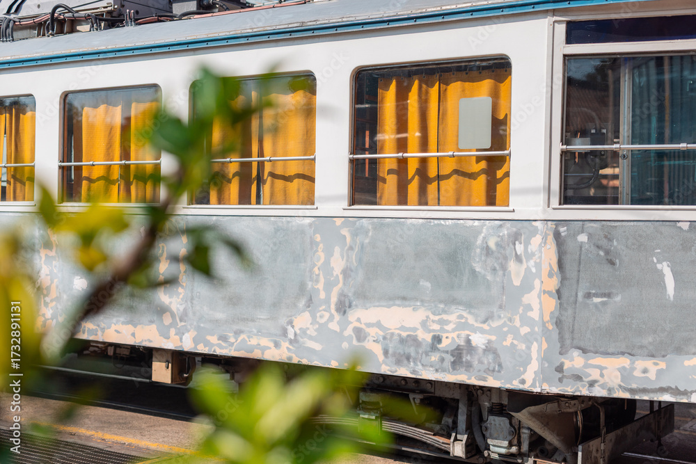 Obraz premium Old tram of opicina tram system is being renovated on the siding tracks of Opicina train station, visible orange curtains and sanded down body of a tram