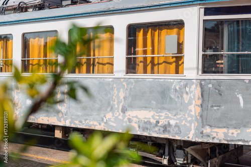 Old tram of opicina tram system is being renovated on the siding tracks of Opicina train station, visible orange curtains and sanded down body of a tram