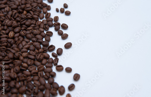 Macro of roasted coffee scattered on a white background