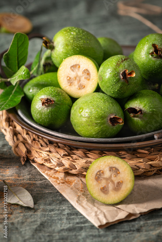 Wallpaper Mural A rustic still life with ripe pineapple guavas, some cut open to reveal the fleshy pulp, on a small plate and in a basket Torontodigital.ca