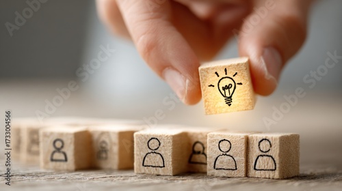 Hand choosing lightbulb concept cube for team members represents new idea