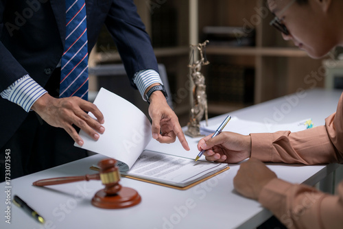 A man and a woman are sitting at a desk with a piece of paper in front of them