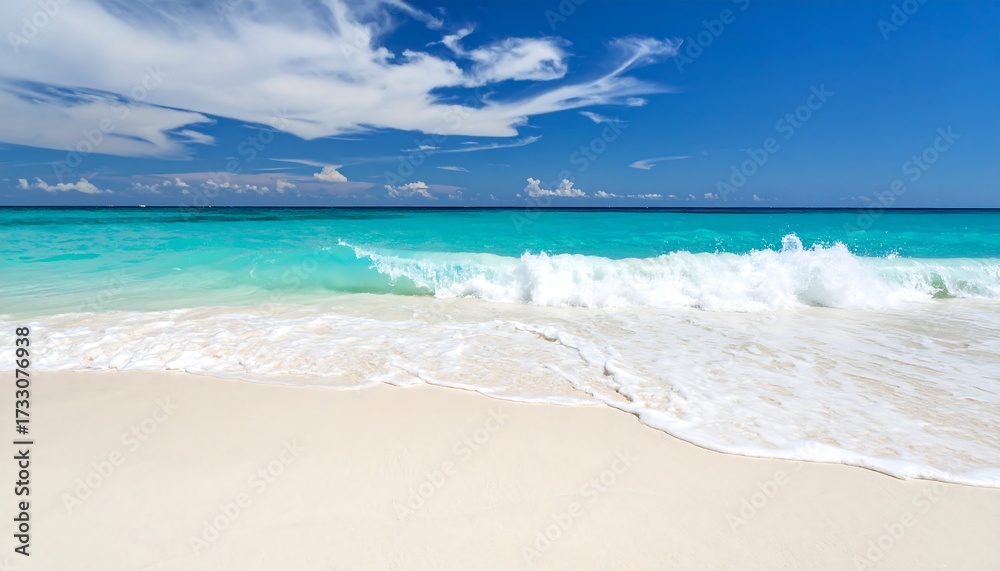 Fototapeta premium Turquoise ocean wave rolling onto white sand beach under a blue cloudy sky Tropical paradise.