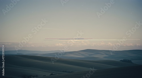 Vast rolling hills landscape under a serene sky with subtle vintage film effect