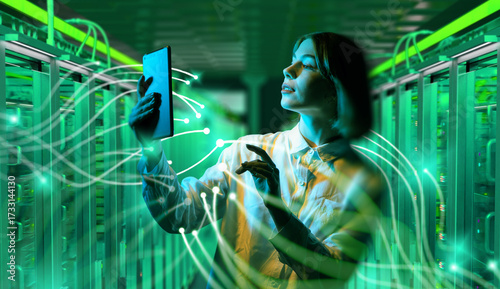 Woman with tablet in data center surrounded by digital network connections, managing servers and cloud computing technology. Information Technology.