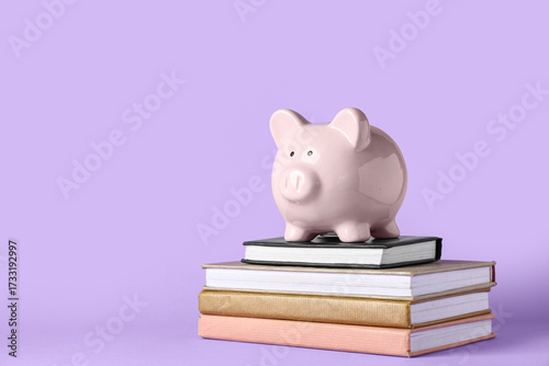 Piggy bank with books on li...