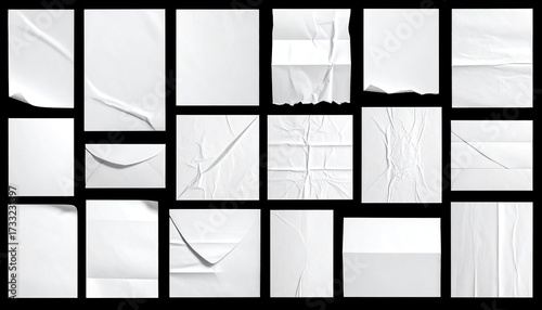 Assortment of white paper sheets with folds, tears, and textures against black