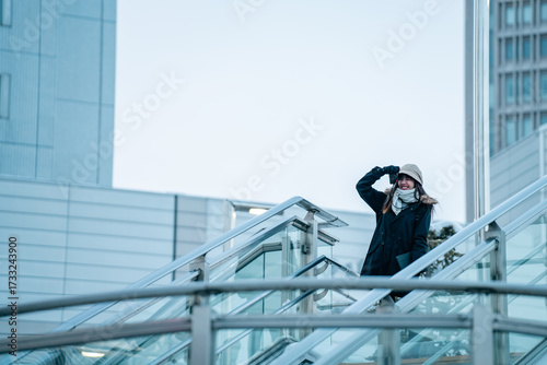 Asian woman photographer using camera taking picture of urban cityscape architecture building in winter season. Young woman traveler enjoy outdoor active lifestyle travel and walking city street.