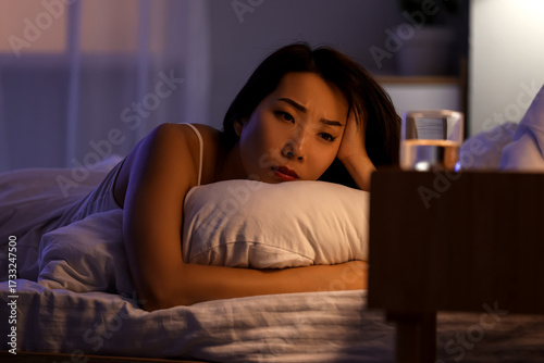 Young Asian woman with pillow cannot sleep in bedroom at night