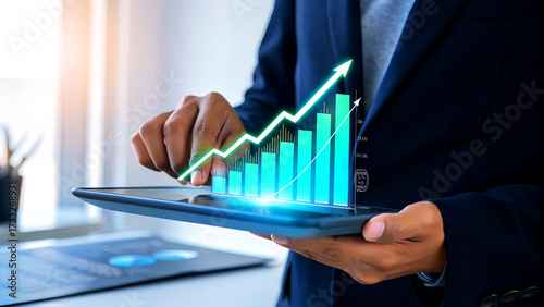 Dynamic businessman analyzing financial growth chart on tablet, projecting success and investment strategy in modern office