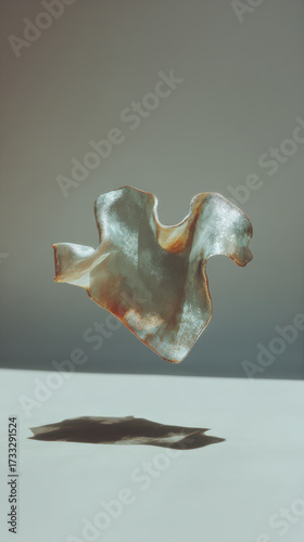 A flowing abstract shape resembling molten metal, reflecting light with soft curves and smooth textures, creating a sense of movement and depth