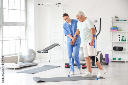 Senior man with crutches an...