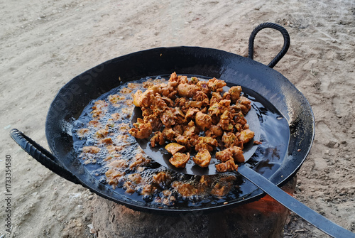 Crispy pakoras (fritters) being fried in a traditional pan. Freshly made and golden-brown, these tasty snacks are perfect for tea time or special occasions. This is a popular street food in India