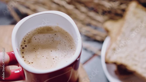 Hand put a red cup of coffee on wooden plate in morning and feeling fresh ready to work.