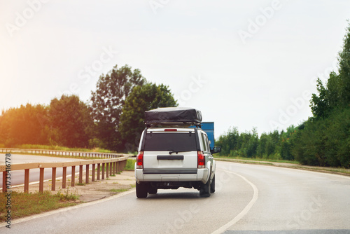 Family vehicle with roof tent on scenic road trip