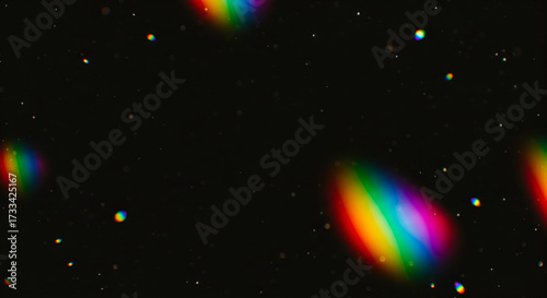 Rainbow prism light flares on a dark background with dust for atmospheric effect