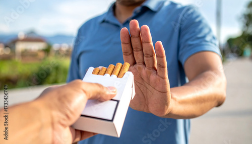 A man refuses when his friend offers him a cigarette