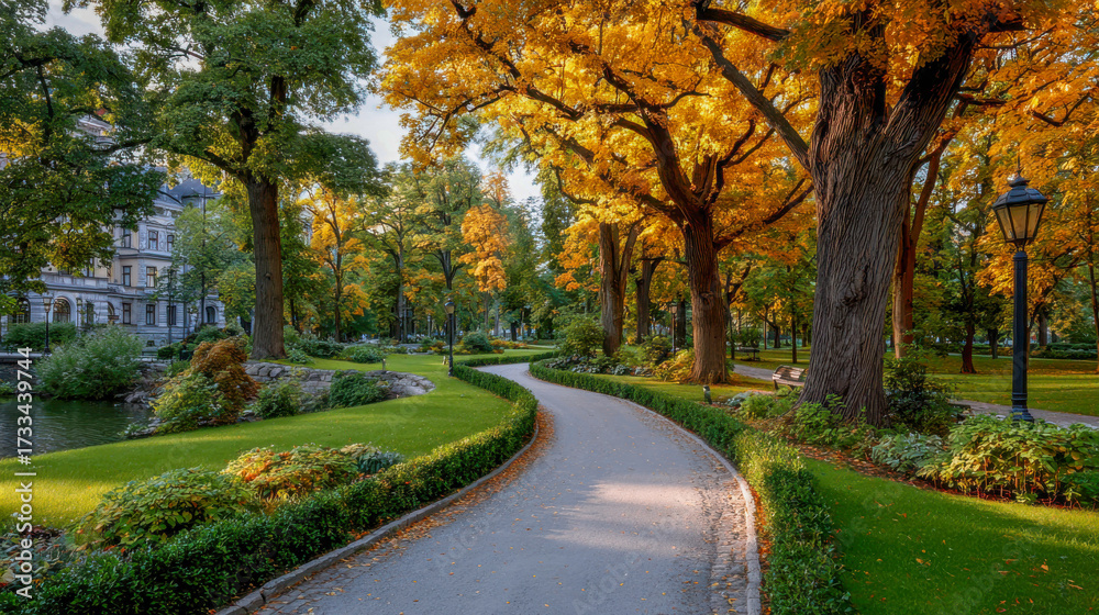 Naklejka premium Scenic park pathway surrounded by vibrant autumn trees, lush greenery, and a tranquil pond, creating a serene atmosphere for leisurely strolls and relaxation