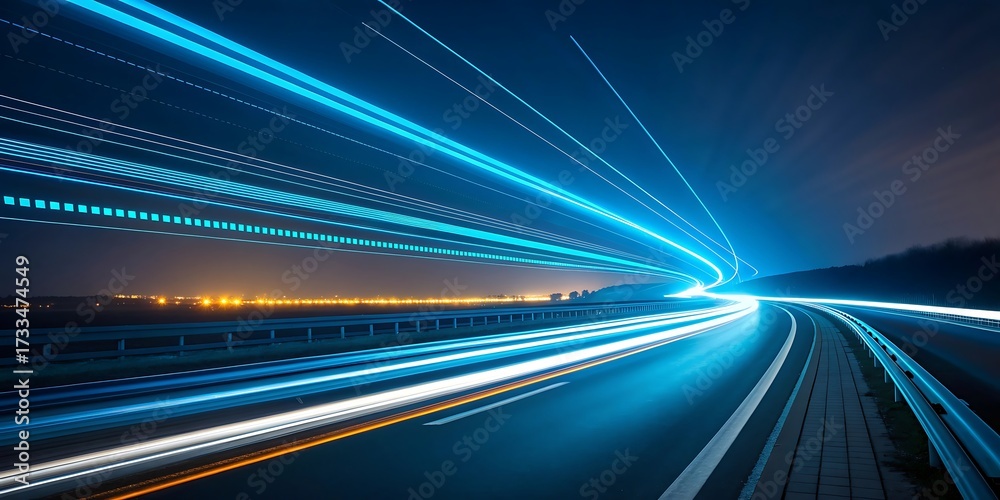 Obraz premium Streaks of vibrant blue and white light illuminate a dark highway at night creating a sense of speed and futuristic motion
