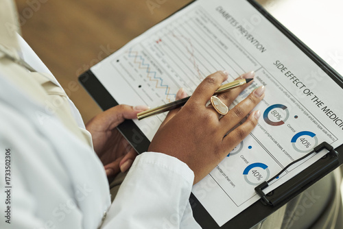 Tablou pe pânză Closeup of Black female medical professional holding clipboard, analyzing diabet