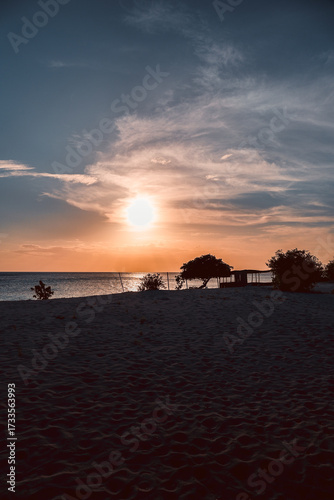 Floating in the waves at sunset, sun just above horizon, going down, orange sky, tranquil sea. Peaceful moment, vacations, summer mood. Dominican Republic. Horizontal video.