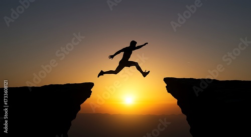 Silhouette of a person jumping across a gap at sunset