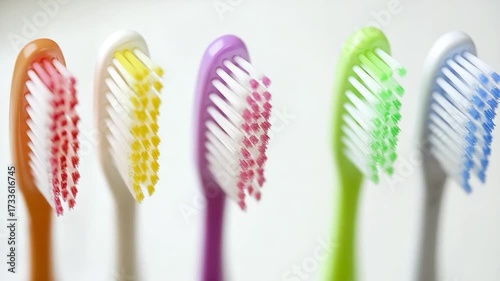 A row of toothbrushes aligned on a surface, ready for use