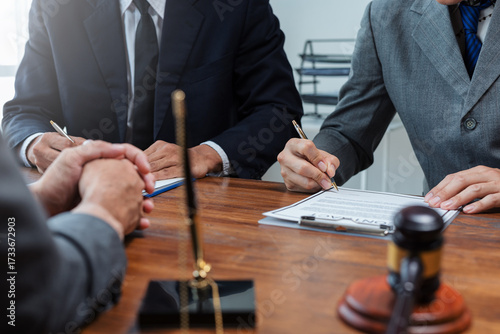 Foto Lawyers assisting a client with signing a legal contract agreement, discussing i
