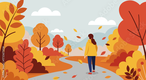 Woman walking on scenic autumn path surrounded by vibrant fall foliage and falling leaves enjoying the crisp air
