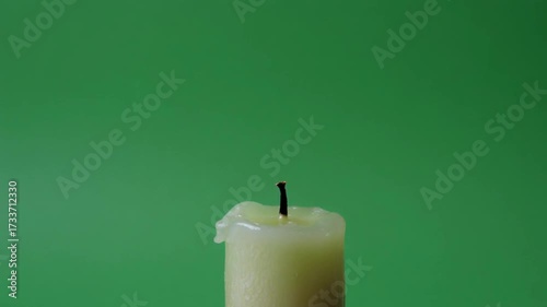 A candle burns in a calm setting, then a sudden wind makes the flame flicker violently before going out. Greenscreen background, HD