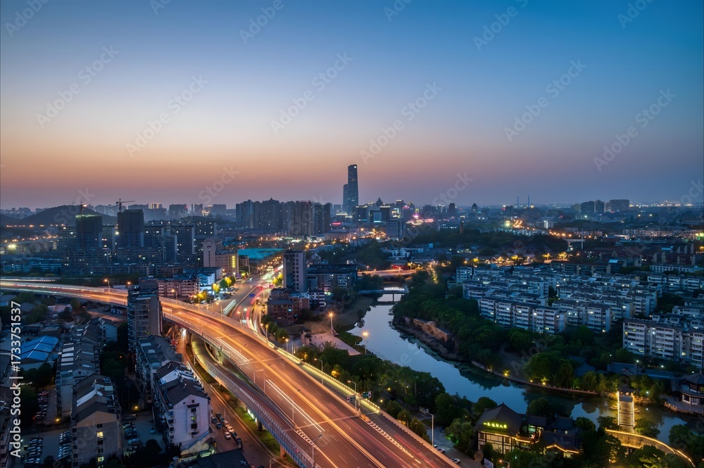 Obraz premium Aerial view of Zhenjiang China city skyline at dusk with illuminated highways flowing through urban landscape by river