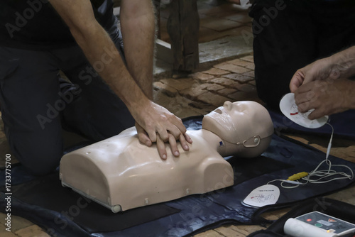 Fotografi Learn CPR techniques on training dummy with focus on chest compressions and AED