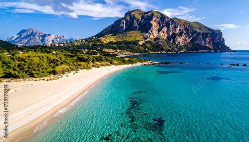 Fototapeta Naklejka Na Ścianę i Meble -  Pristine beach meets vibrant turquoise water, dramatic mountains