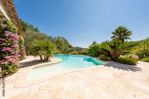 Luxury Mediterranean villa garden with swimming pool and palm trees — summer holiday atmosphere in the French Riviera
