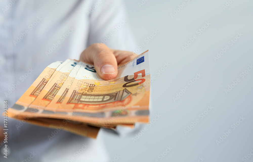 Εκτύπωση καμβά Close-up of a hand giving out several fifty euro banknotes
