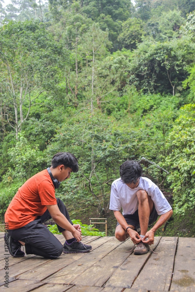 © Queenmoonlite Studio - Two Young Men Tying Shoelaces Before Hiking Through Lush Green Forest Trails Adventure Outdoors © Queenmoonlite Studio - Two Young Men Tying Shoelaces Before Hiking Through Lush Green Forest Trails Adventure Outdoors
