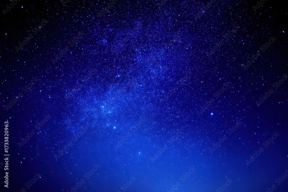 Fototapeta premium A deep blue night sky filled with countless twinkling stars, creating a serene and mesmerizing cosmic scene