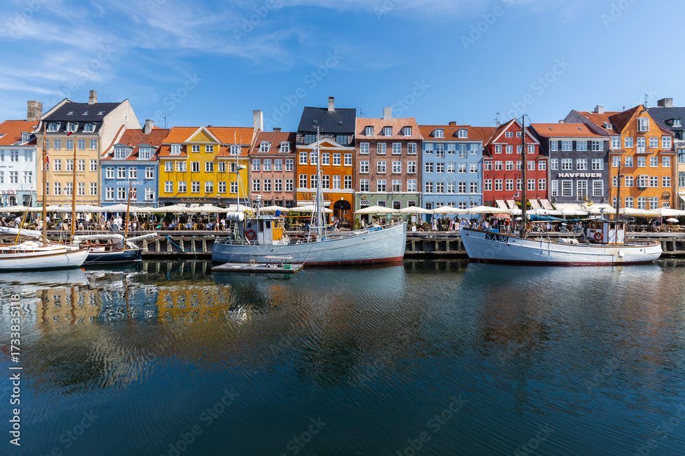 Fototapeta premium Copenhagen, Denmark 07-20-2025 The historic waterfront Nyhavn is a canal in the centre of Copenhagen and known for its brightly colored buildings, historic ships and the author Hans Christian Andersen