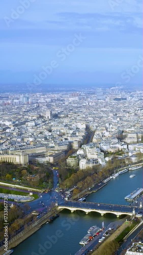 Spectacular vertical video aerial of Paris Seine River with Pont d'Iéna bridge - Haussmann boulevards stretching to horizon. 4K drone footage captures boats - tree-lined banks. Premium mobile content.