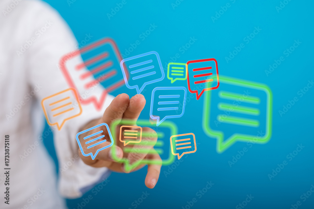Fototapeta premium Hand touching holographic chat bubbles. Depicts online communication, notifications and digital messaging in modern technology.