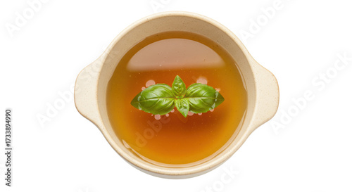Slika na platnu Chicken broth in bowl isolated, clear soup with basil leaf garnish for healthy e