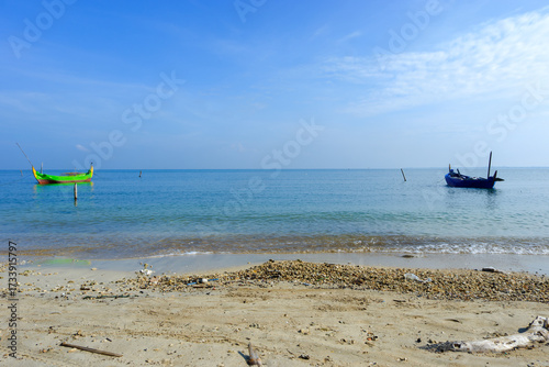 tropical beach with fishing boats rest under a bright blue sky, fisherman village