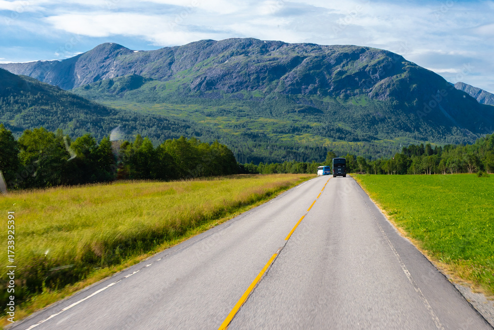 Naklejka premium The village of Grodas in Norway, which is on the Hornindalsvatnet lake, the deepest lake of Europe and surrounded by amazing lush nature of green fields, impressive rock formations and mountains