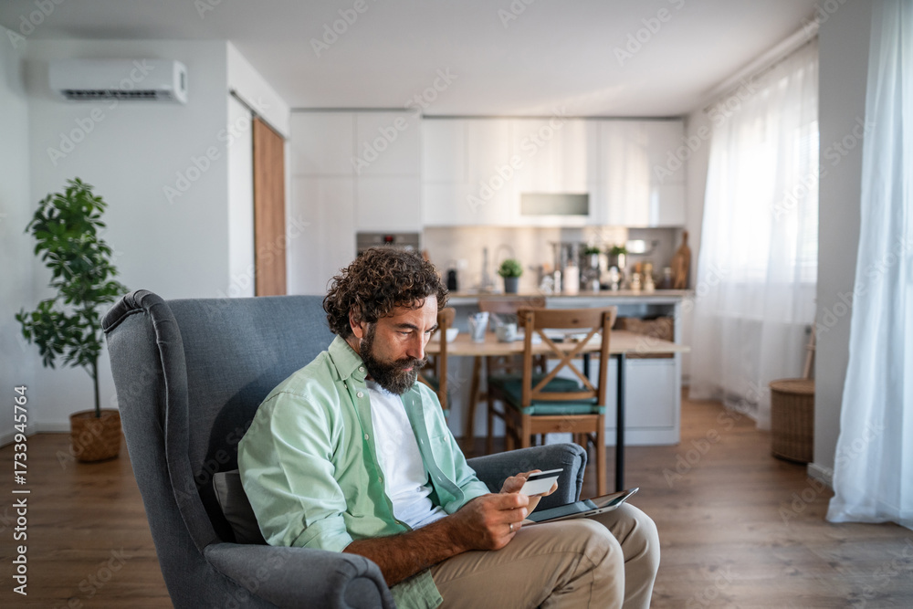 Fototapeta premium Man shopping online using tablet and credit card