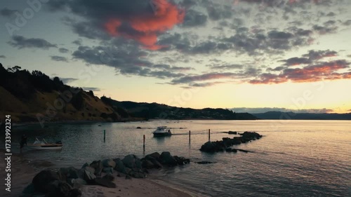 A small fishing boat pulls into the shore at sunset.
