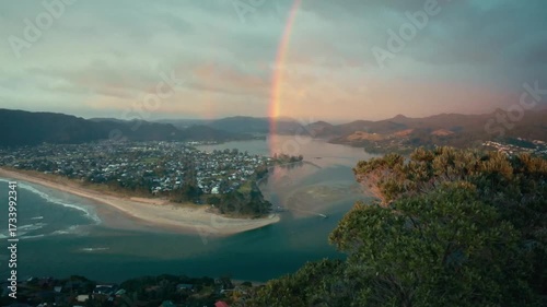looking out over a beach side town with a rainbow in the background.