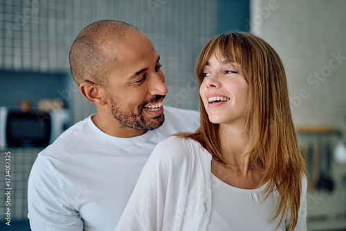 Cuadro en lienzo Smiling multiracial couple laughing together in a intimate home setting, express