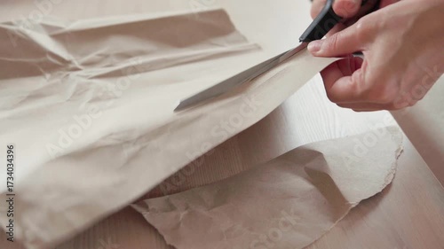 4K Ultra HD Close-up Shot Woman Hands Cutting Paper Sheet With Metal Scissors Sharp Blade on Wooden Office table Background Professional Business.