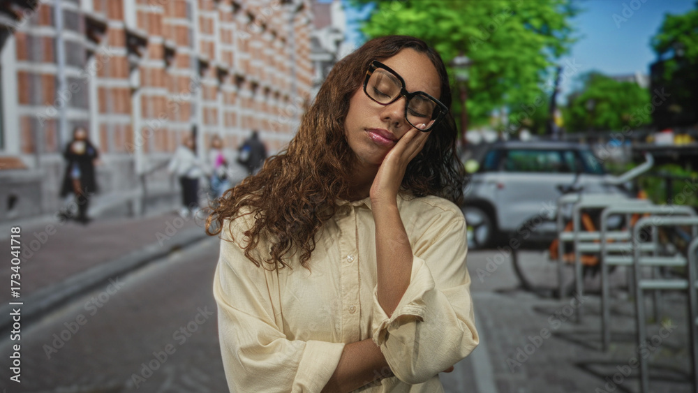 Fototapeta premium Woman with hand on cheek and closed eyes touching face while standing on street near parked car and bike rack; sleepy solitude.